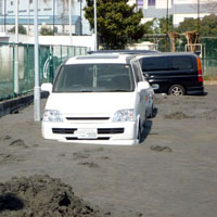 液状化でタイヤが半分埋まった車。新木場地区